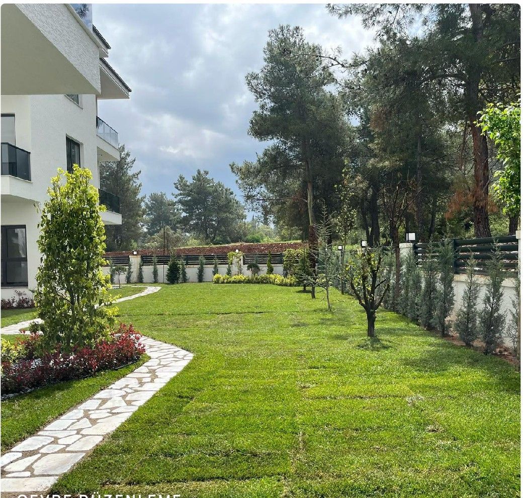 Environmental design with lawn, flower groups and a natural stone path